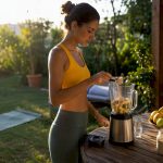 Une jeune femme prépare son smoothie au maca pour bien démarrer la journée.