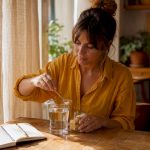 Une femme prépare une boisson pour stimuler sa libido sur la table de la cuisine.