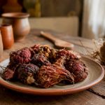 Des racines de maca rouge séchées présentées sur une assiette au style rustique