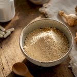Poudre de racine de maca posée à côté d’un flacon de comprimés pour la thyroïde