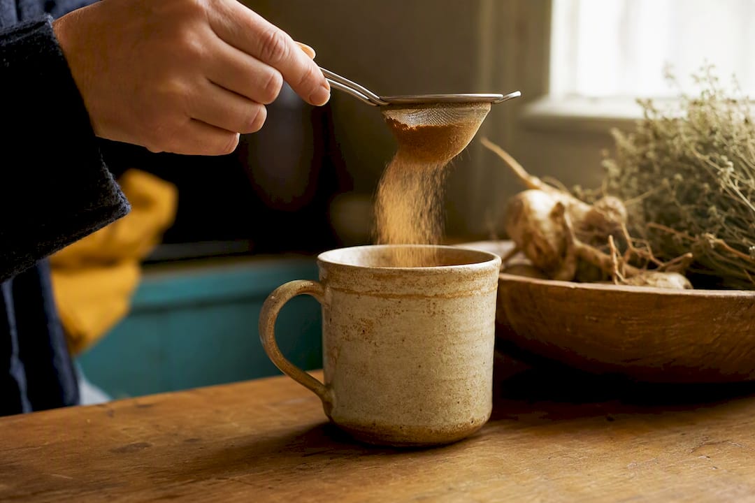 Une cuillère de poudre de chicorée prête à être versée dans une tasse