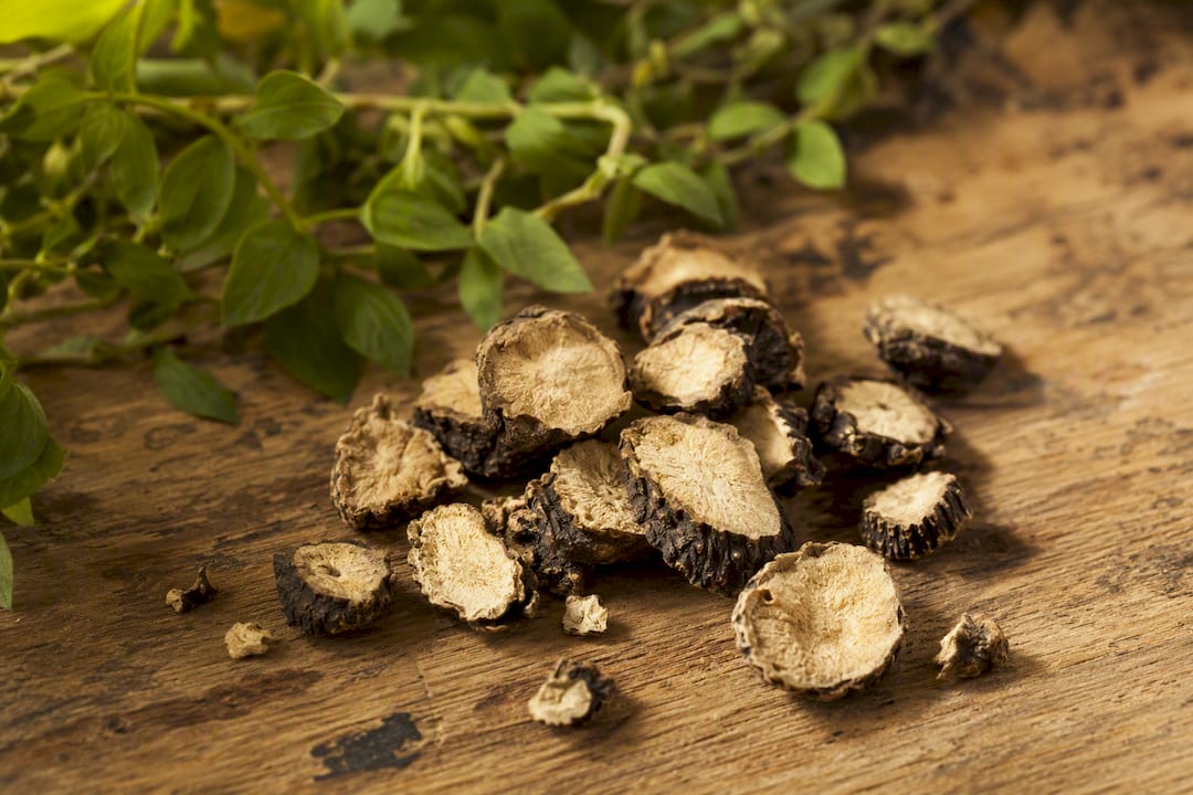 Racines de maca noire tranchées sur une surface en bois